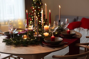 Festive table setting in room decorated for Christmas. Bokeh effect