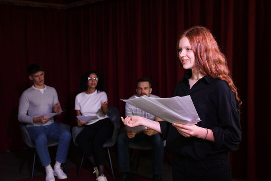 Professional actors reading their scripts during rehearsal in theatre