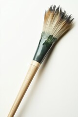 Fototapeta premium A single Japanese calligraphy brush resting horizontally on a clean white surface. The brush has a polished wooden handle and bristles with a slight taper.
