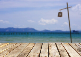 Fototapeta premium Wooden table top on the beach or sea.Party on the beach sunshine time concept.For montage product display or design key visual layout.View of copy space.