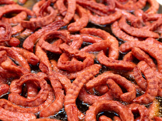 Fototapeta premium Sausages fried in a large pan. Asian street food Thailand.