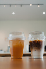 Iced coffee latte and iced tea in takeaway glass put on wood table