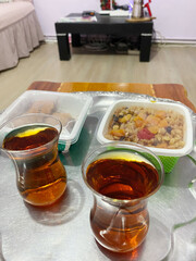 Turkish tea and traditional desserts. Two glasses of Turkish tea served on a tray with traditional Turkish desserts in a cozy living room setting