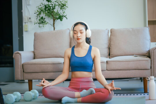 An Asian teenage girl exercises in her room to relax, stretch, and improve health.Regular exercise enhances endurance,strength, balance, emotional control, fitness, and aids in effective weight loss