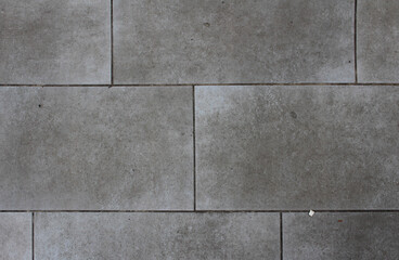 Texture of square paving tile. Pattern of tiles in the street. Close up of gray concrete pavers background.	