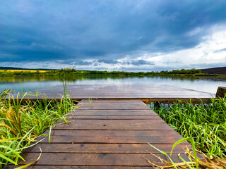 panorama with wooden pontoon overlooking the lake at sunset