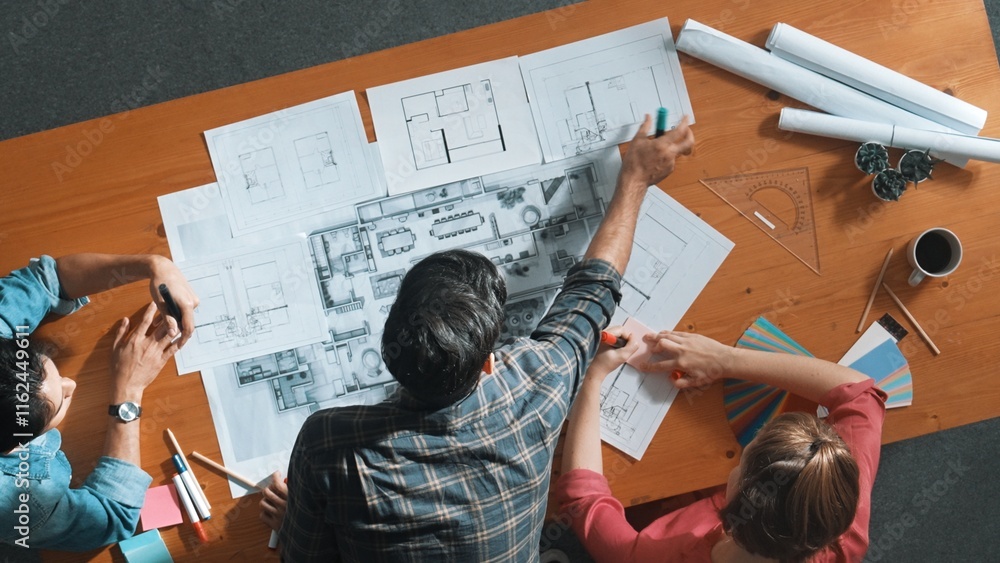 Poster group of people looking at blueprint while brainstorming idea. top view of engineer team looking and