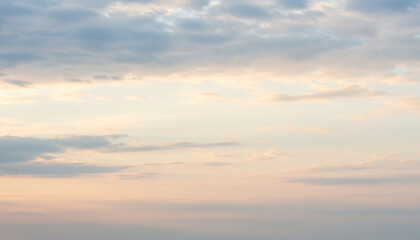 Obraz premium Soft pastel sky at sunrise with delicate clouds, providing a serene and tranquil scene for backgrounds or nature-themed designs.
