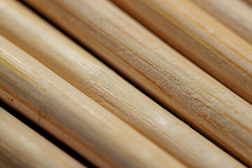 Close-up of smooth, light brown wooden sticks arranged in parallel lines.  Texture and grain are visible.