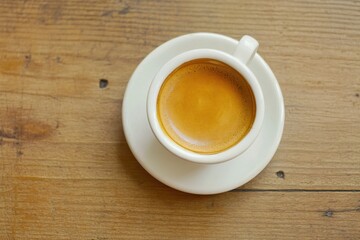 Fototapeta premium Freshly Brewed Espresso in White Cup on Wooden Table Surface with Natural Light