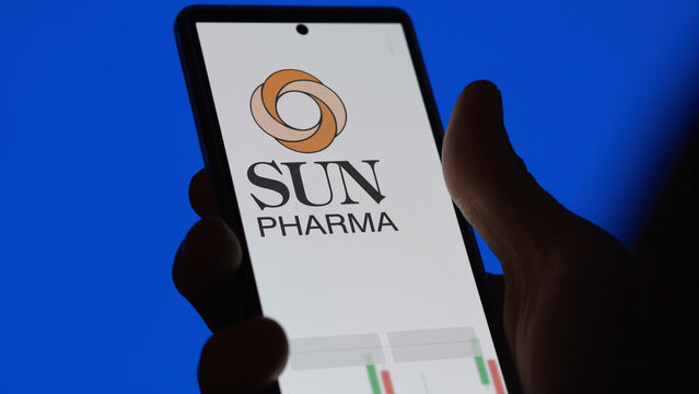 Sun Pharma stocks, an investor analyzing the sun pharma price on a screen. A phone shows the shares prices of Sun Pharma