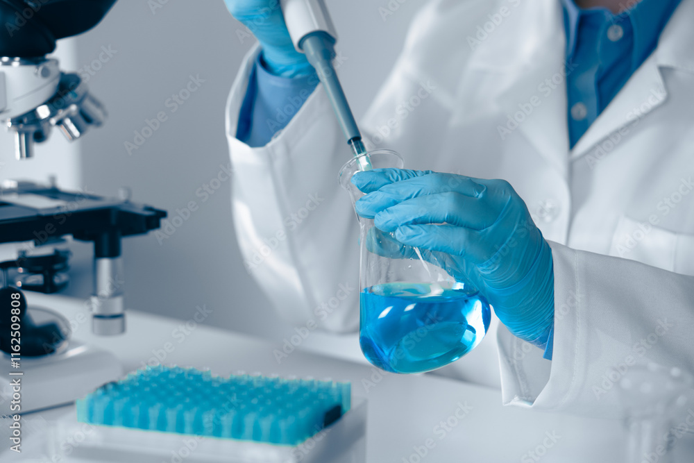 Poster a skilled laboratory technician is engaged in their work utilizing a pipette while wearing blue glov