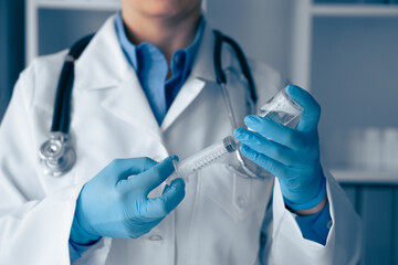 A dedicated medical professional meticulously prepares the syringe with careful precision, ensuring...