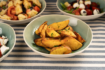 baked potatoes and various salads served on the table for dinner