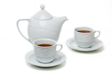Elegant white tea set with steaming cups on saucers surrounded by tranquility of afternoon tea time