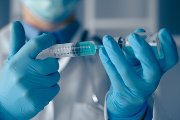 A Medical Professional is meticulously preparing a syringe filled with a vaccine in a clinical setting, ensuring all health and sanitation protocols are strictly adhered to for patient safety