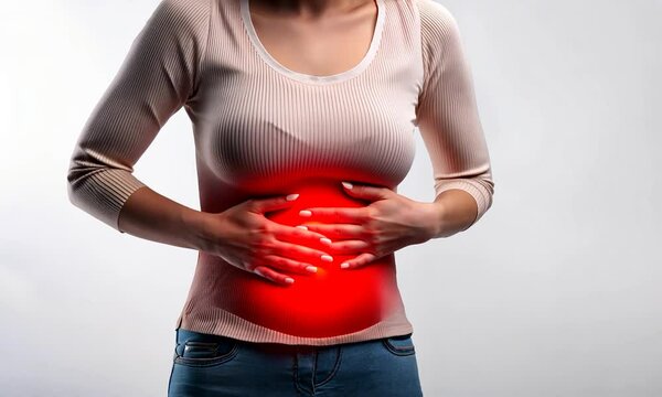 Concept: abdominal pain, abdominal discomfort. Woman holds her hand in the abdominal area.