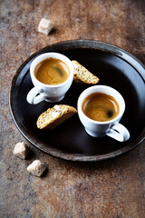 Cantuccini (Italian cookie) and Two Cups Of Coffee on rustic stone background. Copy space.	