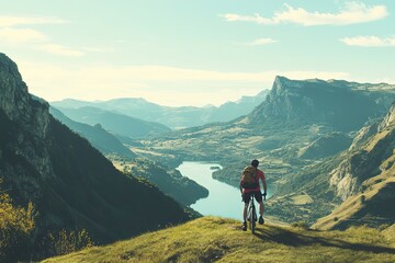 Obraz premium Cyclist pauses atop mountain overlooking valley vista