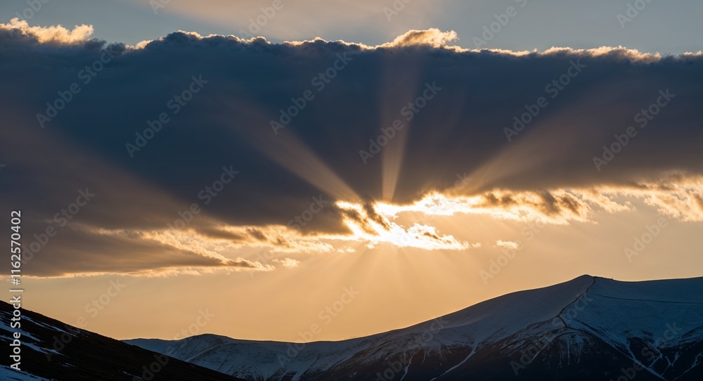 Poster sunset with a few clouds scattered around casting rays of light onto mountain slopes