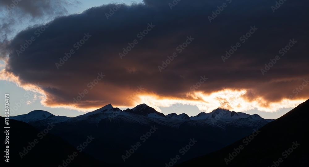 Poster sunset with clouds catching the last light creating dramatic contrast with mountains