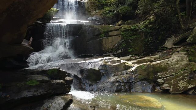 Rising drone shot of Little Bradley Falls, a waterfall in the forest of North Carolina in the Great Smoky mountains.