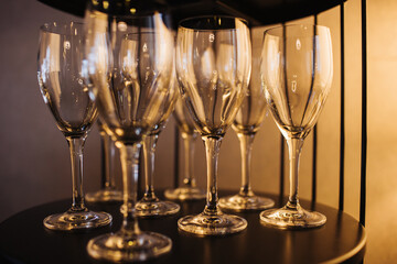 Decorative wine glasses on a festive table. Background of New Year's Eve celebration. Crystal goblets for elegant toasts. Champagne drinking background. Crystal glass set collection.