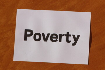 Poverty word written on a white paper