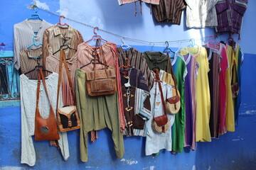 Vêtements colorés berbères accrochés au mur bleu dans la ville de Chefchaouen au Maroc