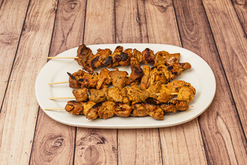 After marinating, the pieces of meat are threaded onto skewers and cooked on a grill or in an oven.