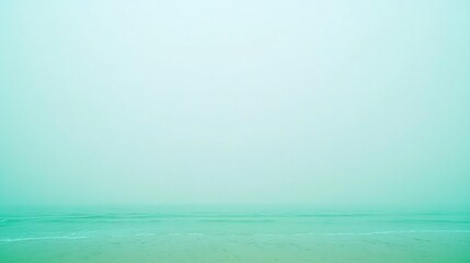 Fototapeta premium Serene Misty Beach Seascape: Calm Ocean and Sandy Shore