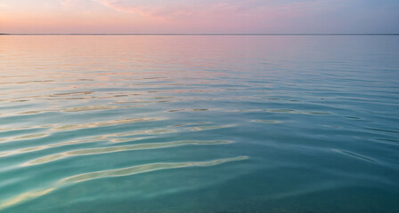 Obraz premium calm sea water surface at sunset. Tranquil ocean view with warm hues and gentle reflections