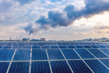 Solar panels and petrochemical plant at sunset