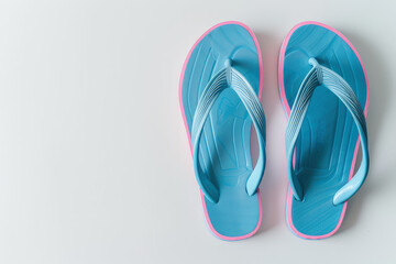 Fototapeta premium A pair of blue flip-flops with pink accents on a white background.