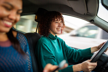 Woman driving car with friend in passenger seat