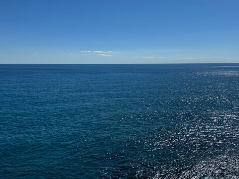 Sea blue glittering water clear sky horizon.