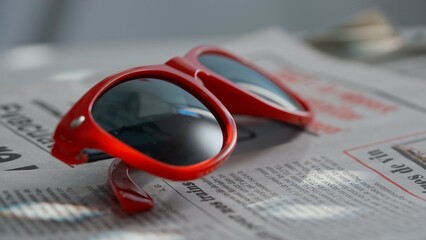 A close up of the glasses on the newspaper.