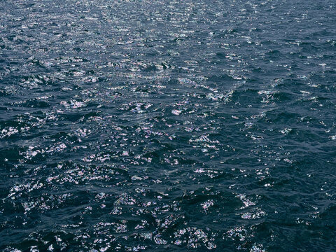 Blue sea glittering shiny water surface.