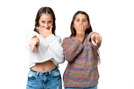 Friends girls over isolated chroma key background pointing with finger at someone and laughing