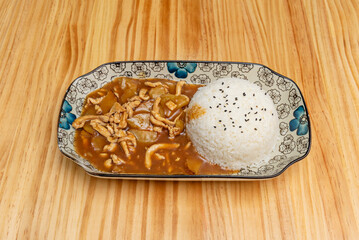 a bowl of white rice with a Chinese chicken stew on a porcelain tray