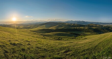 Golden hour sunlight bathes rolling green hills and distant mountains in a breathtaking panoramic view.