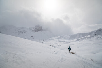person practicing ski touring with an alpine landscape; one person alone in high mountain