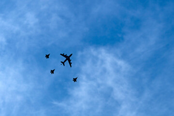 Four military airplanes silhouettes on a blue sky