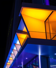 Obraz premium Vibrant geometric shapes illuminate urban architecture at night in a stunning display of colors and design