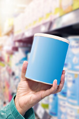 Hand with blue metal jar of dry baby food