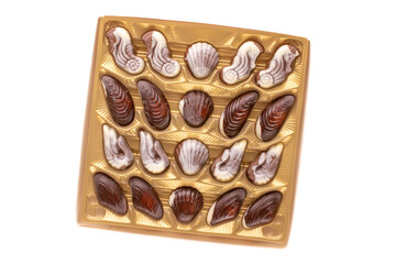 Several chocolate candies in a paper box on a white background, close-up, top view.
