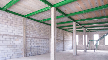 Metal beam and concrete block wall with column inside of new office building room in construction...