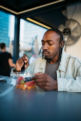 Young man enjoying a fresh fruit salad outdoors