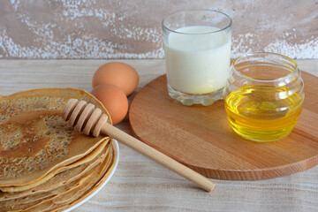 a plate with pancakes on it and a cutting board with milk and honey  