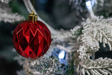 Red Faceted Ornament on Artificial Snow-Covered Christmas Tree